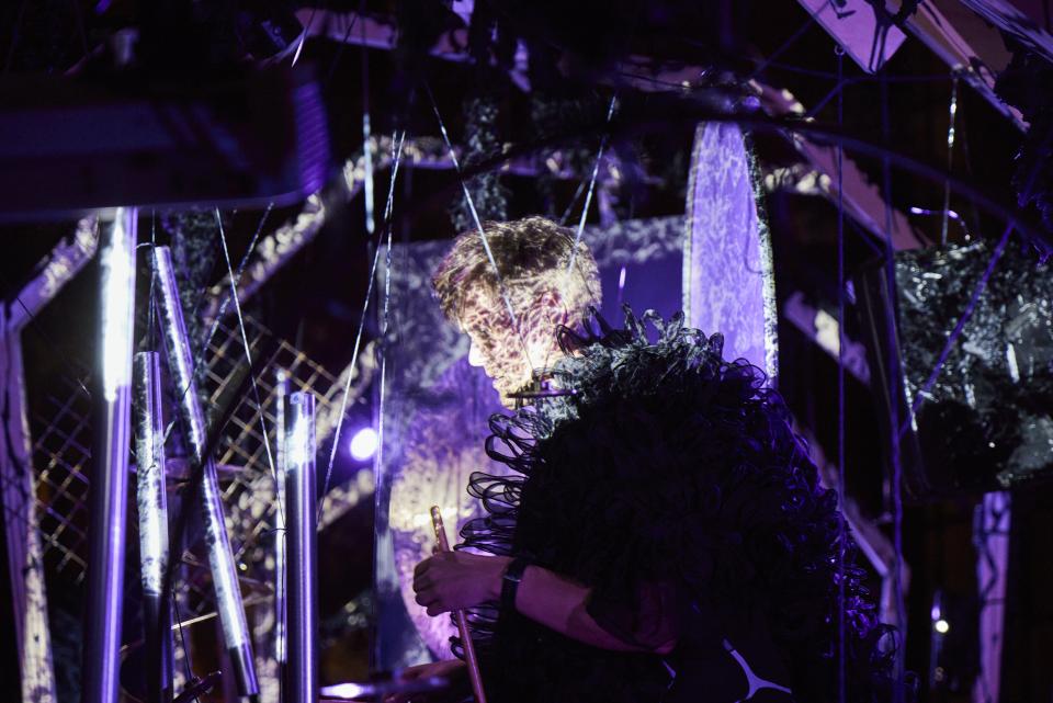 we see the percussionist in the percussion installation in the middle of gongs in the whale-structure with very cool lighting 
