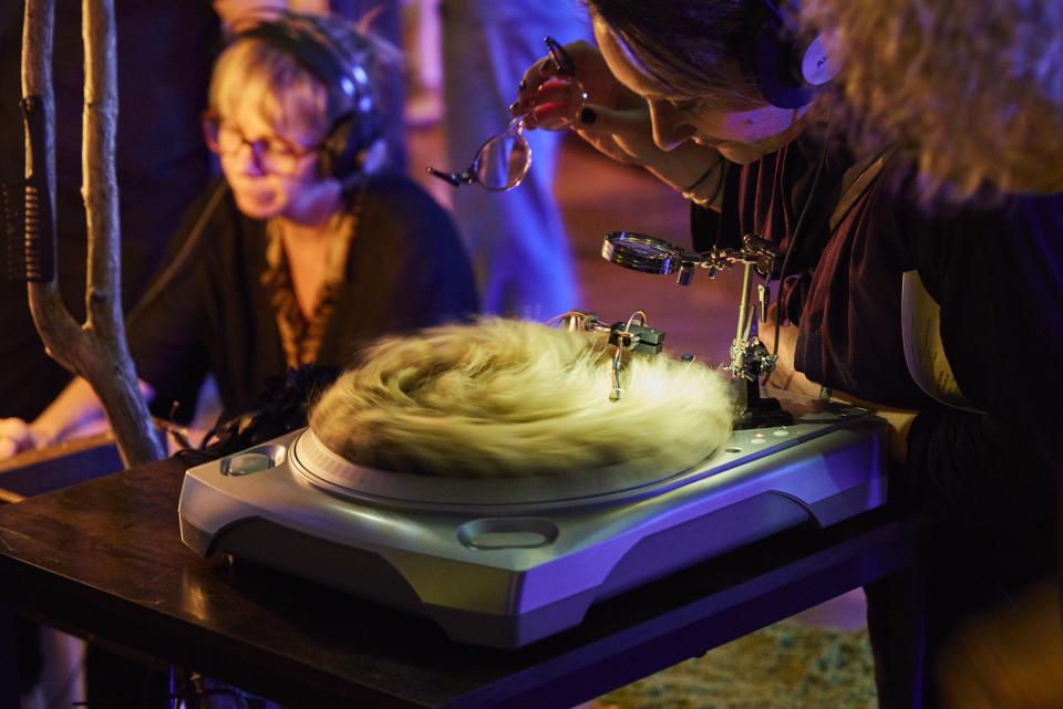 Audience members interact with turntables that instead of a vinyl they have objects on the platter, like fake fure, or earth, with touch microphones they can listen the quality of the material